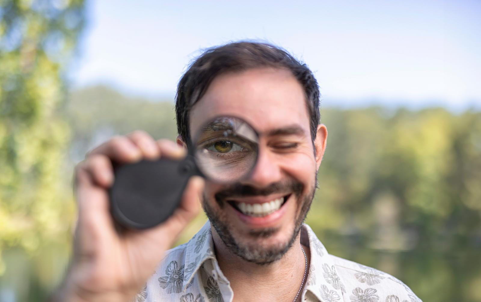 Christian Ploy hält eine Lupe vor sein Auge