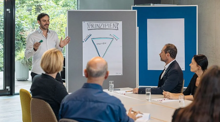 Schristian Ploy bei einer Unternehmensberatung mit 2 Männern an einem Tisch
